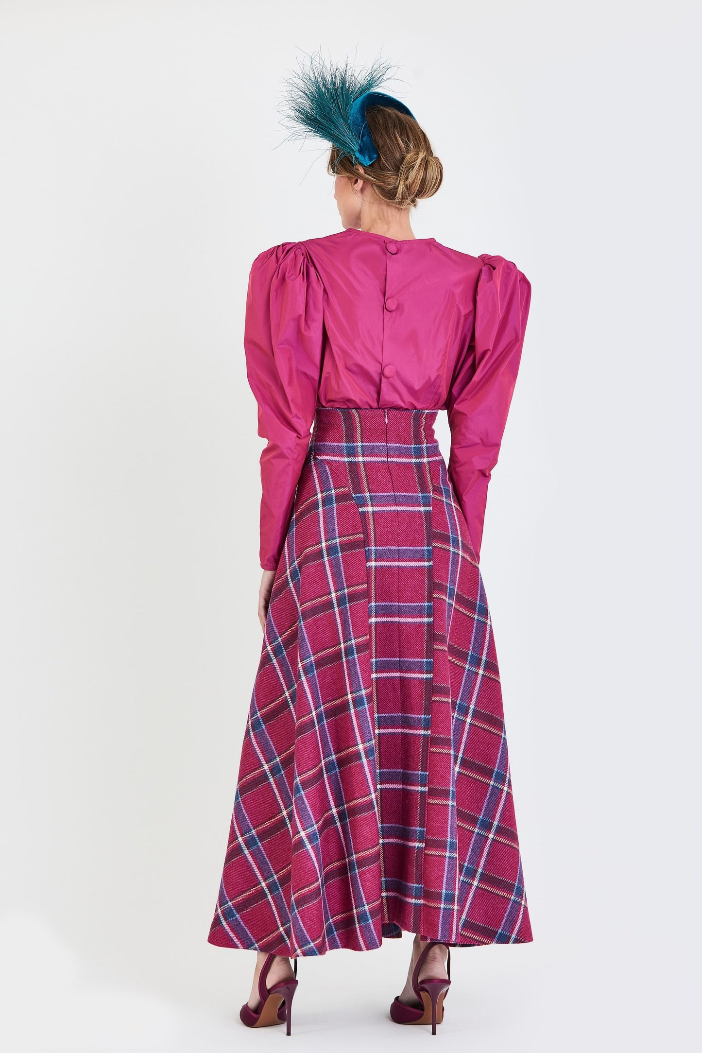 Conjunto de invitada de la colección Otoño Invierno 2025-2026 de Zinnia Brand con blusa en tono fucsia de mangas abullonadas y falda midi de cuadros en tonos fucsia y azul. Un diseño sofisticado y femenino que combina elegancia contemporánea y estilo para eventos especiales.
