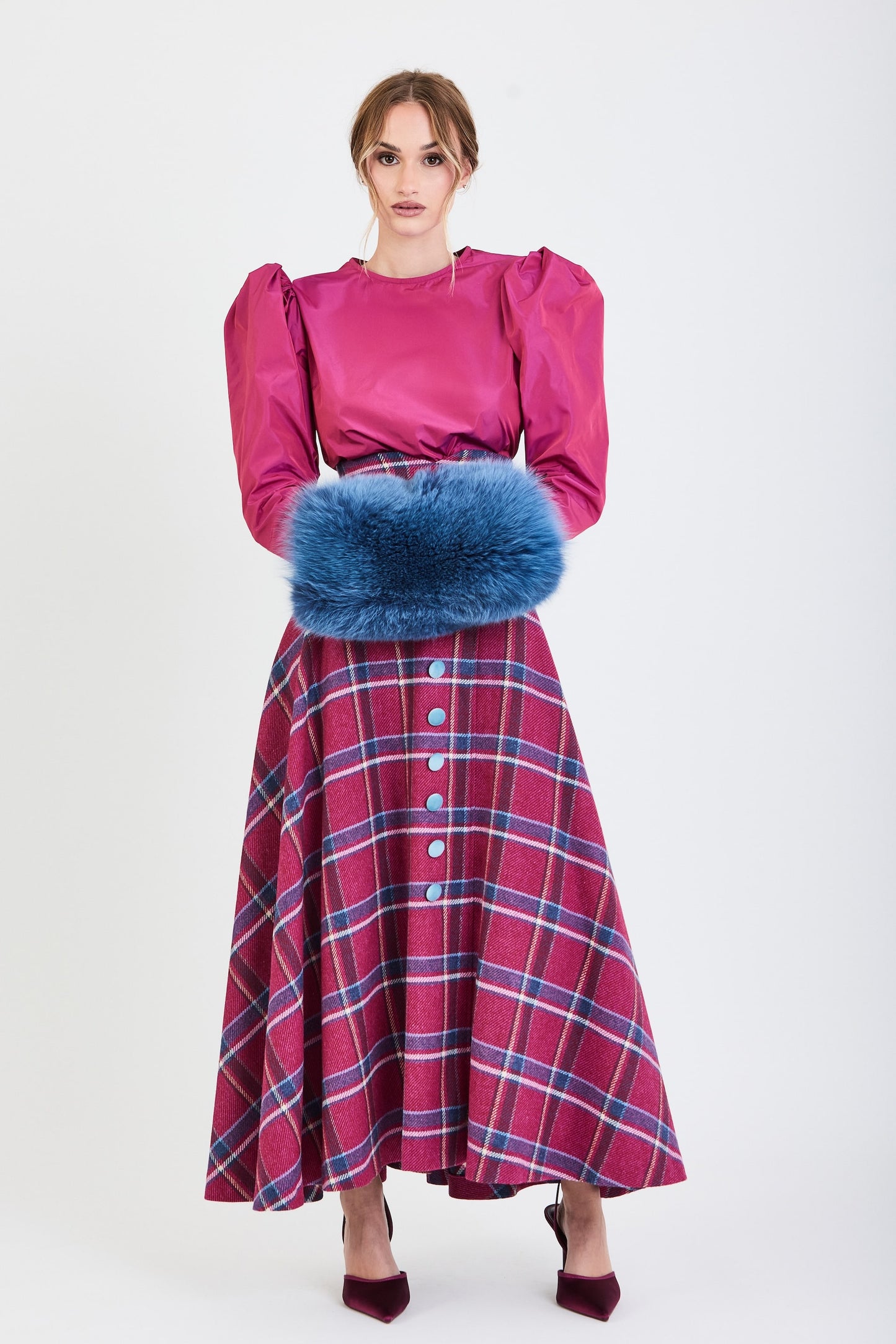 Conjunto de invitada de la colección Otoño Invierno 2025-2026 de Zinnia Brand con blusa en tono fucsia de mangas abullonadas y falda midi de cuadros en tonos fucsia y azul. Un diseño sofisticado y femenino que combina elegancia contemporánea y estilo para eventos especiales.
