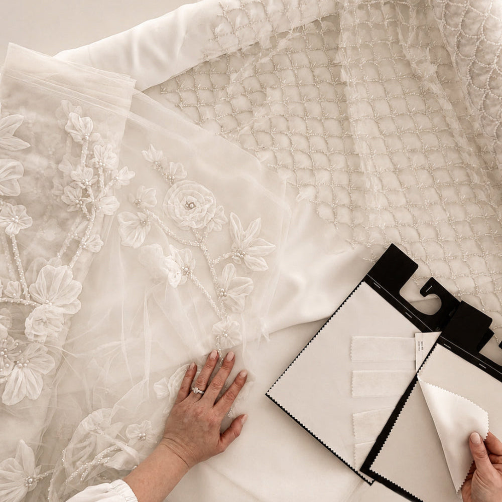 Proceso creativo en el atelier de Zinnia Brand con selección de tejidos de novia, bordados florales y muestras textiles para confección a medida. Una imagen que refleja artesanía, diseño personalizado y el cuidado de cada detalle en vestidos de novia exclusivos.
